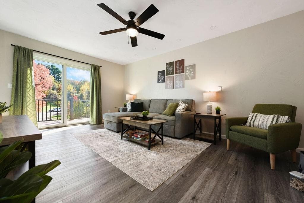 Bright and inviting living space with scenic views through large glass doors. Perfect for morning coffee or cozy evenings in, surrounded by modern decor and all the comforts you need for a relaxing stay!